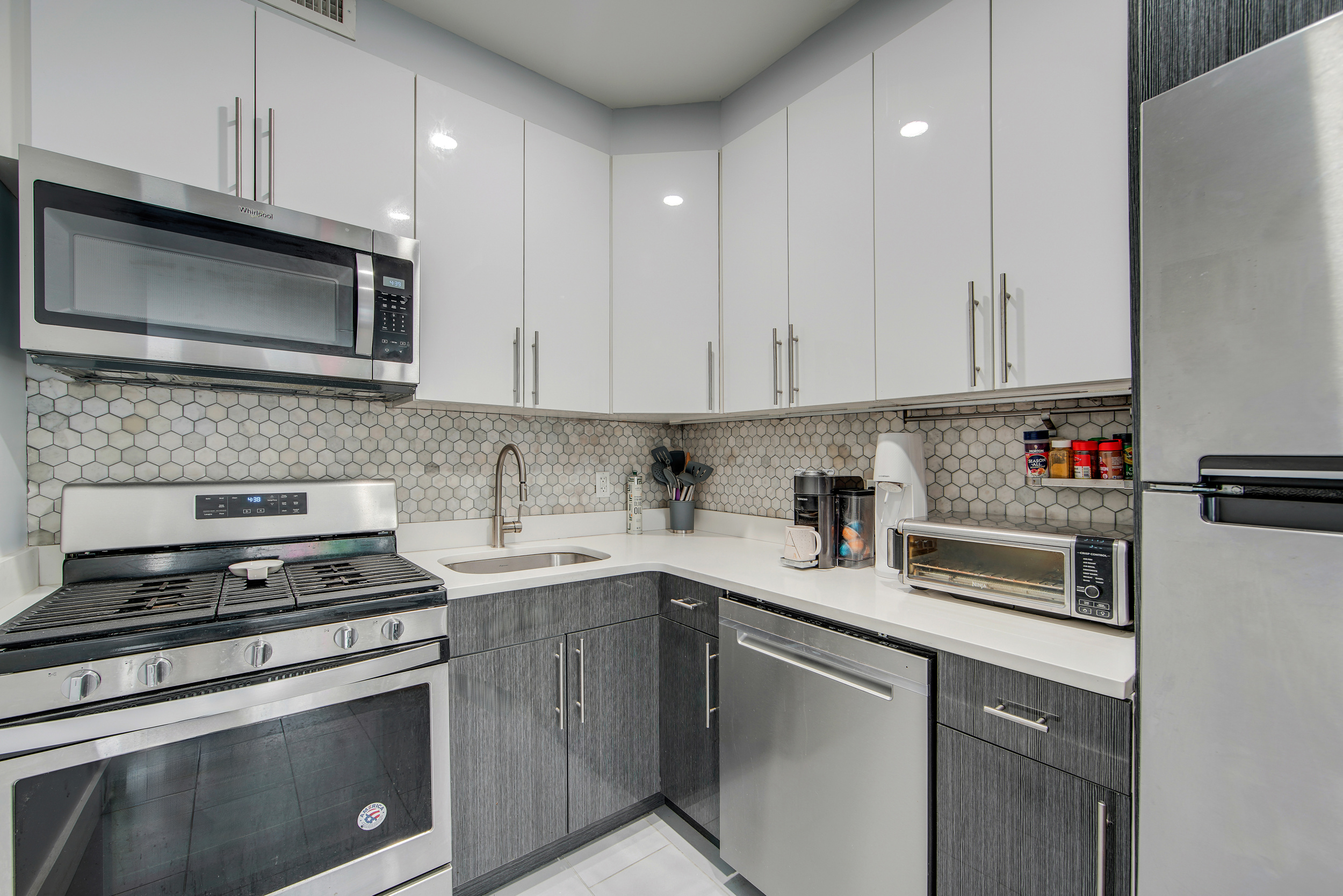 27-34 27th Street, Unit 1B Queens, NY 11102 - Photo 4 of 10 a kitchen with cabinets stainless steel appliances and sink