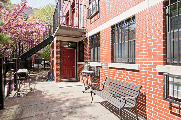 153 Stanton Street, Unit A1 Manhattan, NY 10002 - Photo 2 of 16 a view of a brick building with a bench in patio