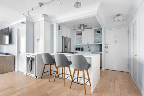 a view of kitchen with dining area refrigerator and wooden floor