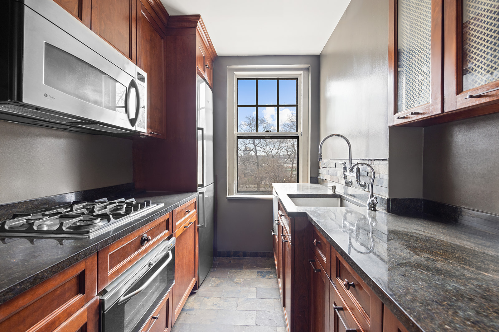 5 Riverside Drive, Unit 3B Manhattan, NY 10023 - Photo 7 of 14 a kitchen with stainless steel appliances granite countertop a stove and a sink