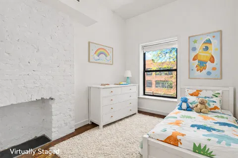 a bed room with a bed and paintings on the dresser