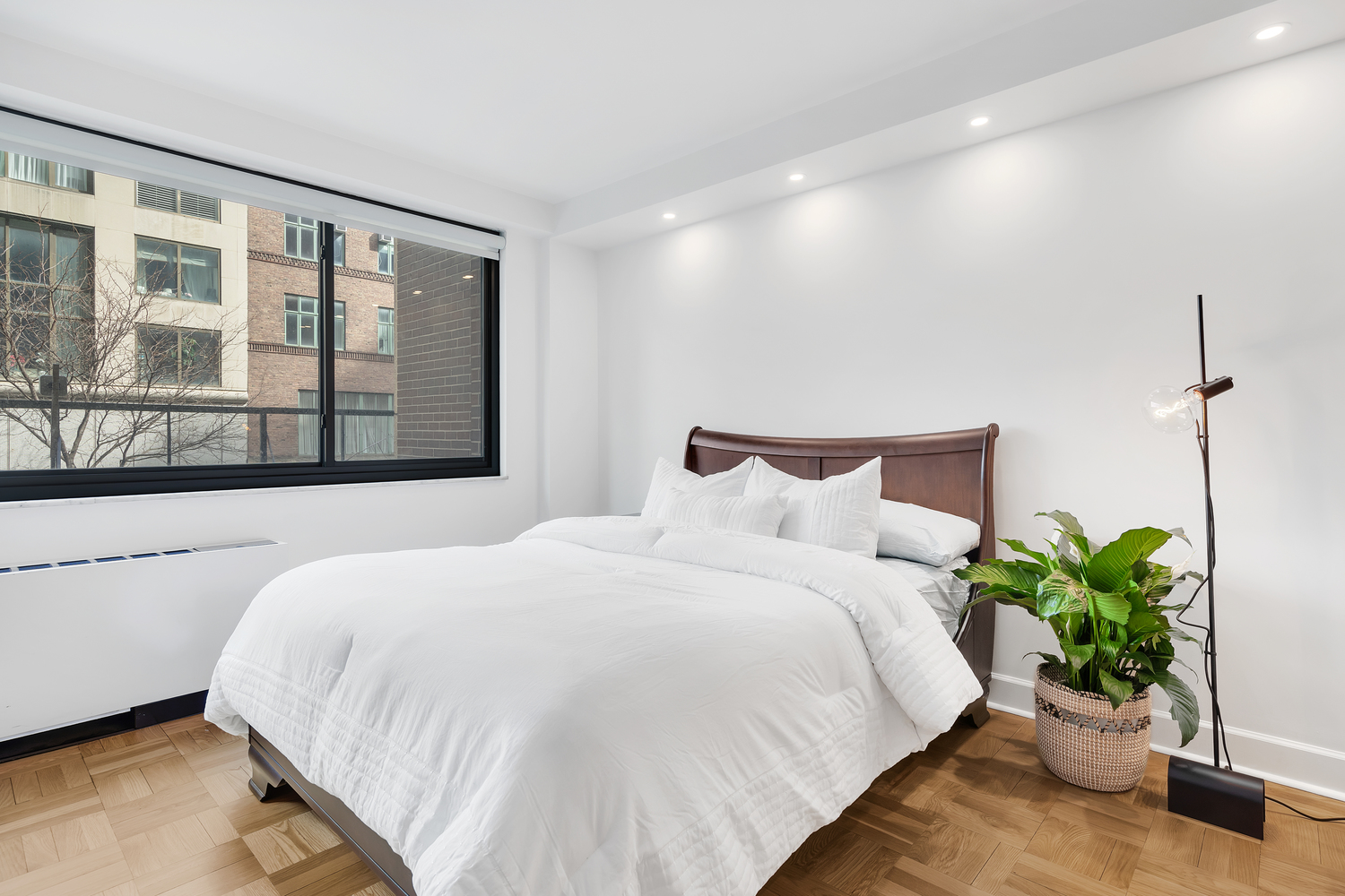 40 East 80th Street, Unit 2C Manhattan, NY 10075 - Photo 4 of 6 a large white bed sitting in a bedroom next to a large window