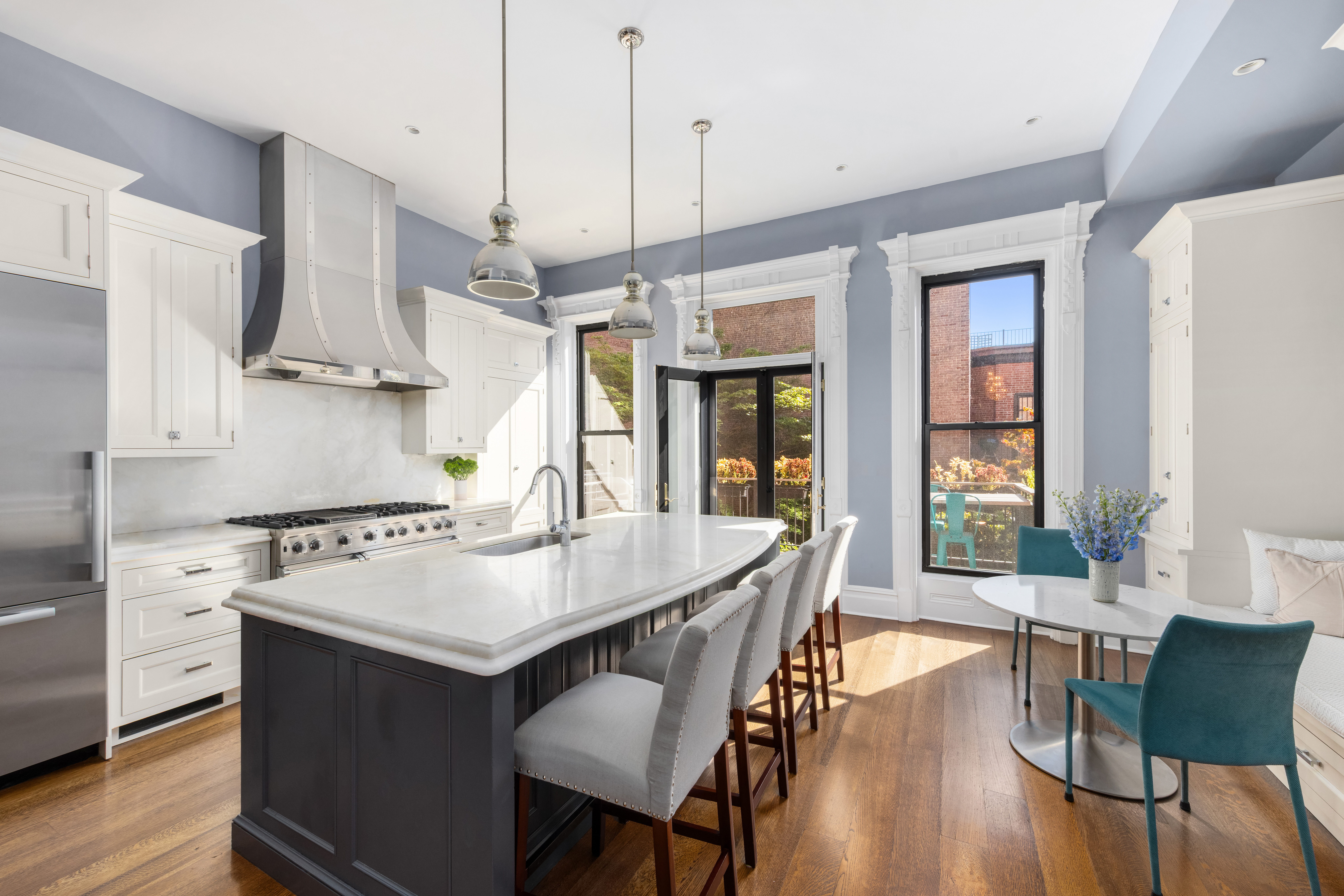 159 6th Avenue, Unit TRIPLEX Brooklyn, NY 11217 - Photo 2 of 19 a kitchen with a dining table chairs and white cabinets
