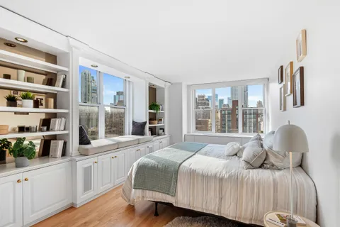 a bedroom with a bed and a large window with the outer view