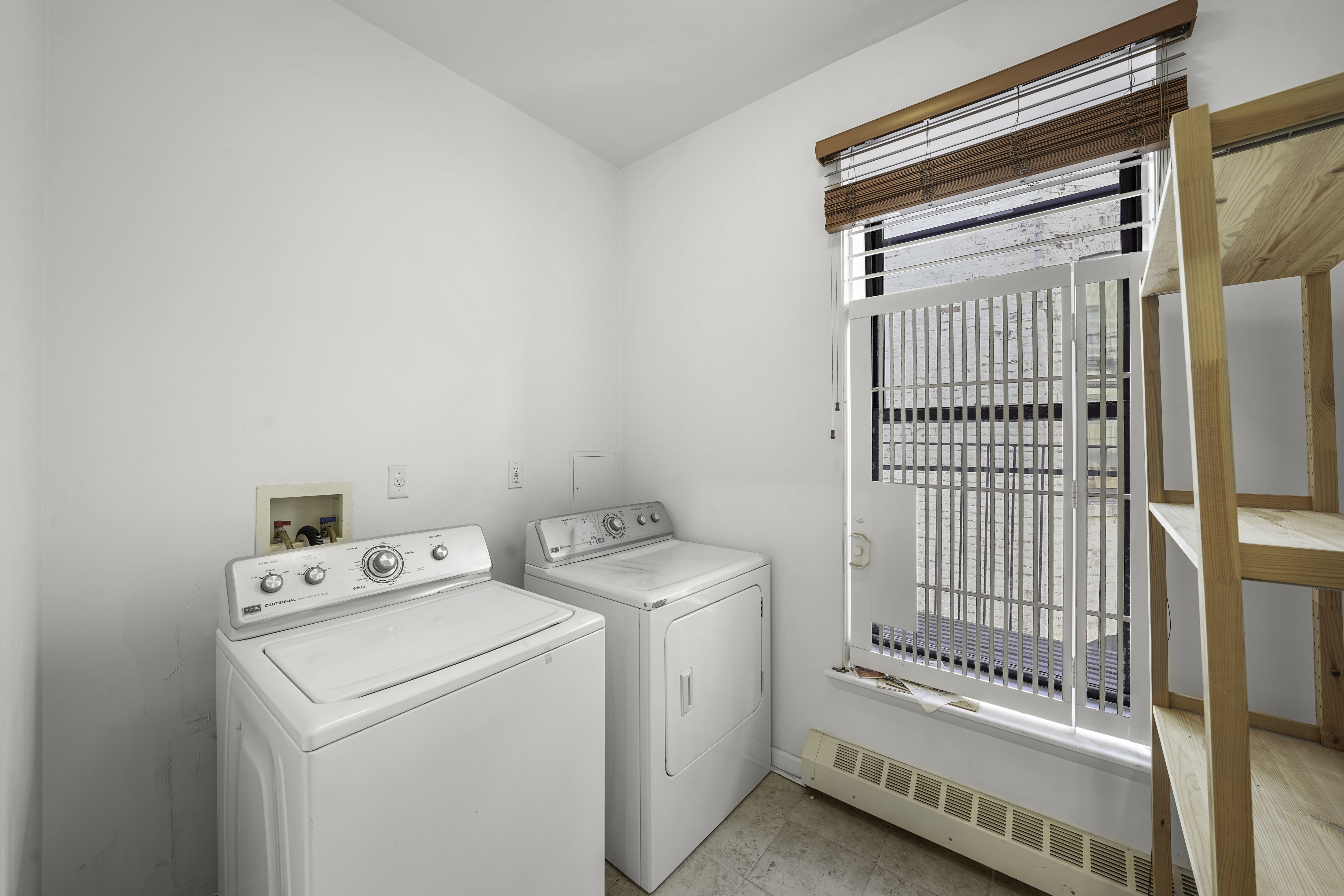 163 Lenox Avenue, Unit 5A Manhattan, NY 10026 - Photo 14 of 16 a view of washer and dryer with bathroom in the background