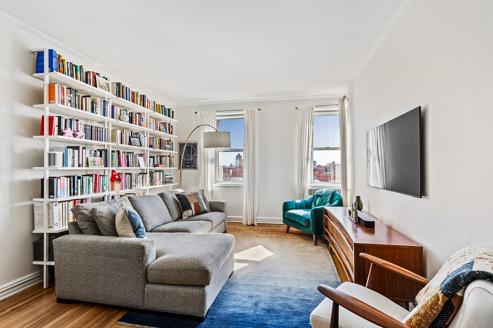 140 East 2nd Street, Unit 5B Brooklyn, NY 11218 - Photo 3 of 7 a living room with furniture and a flat screen tv