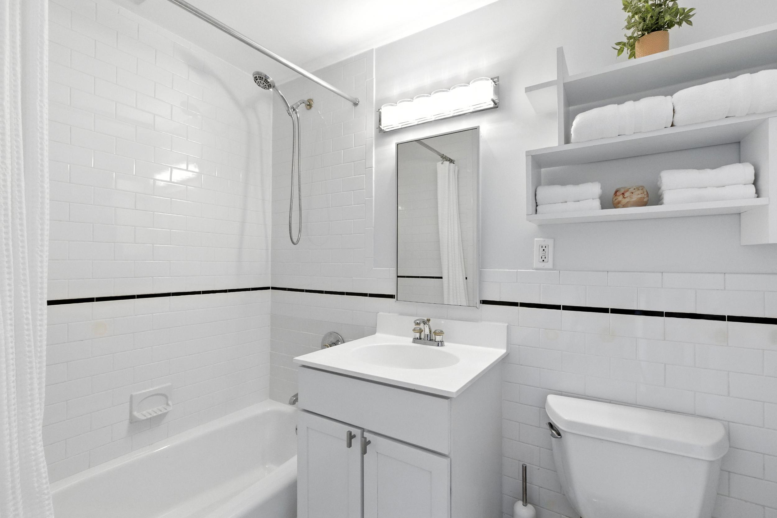 1787 Madison Avenue, Unit 402 Manhattan, NY 10035 - Photo 6 of 13 a bathroom with a sink a mirror a toilet and a shower