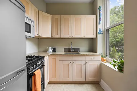a kitchen with stainless steel appliances granite countertop a stove a sink and a white cabinets