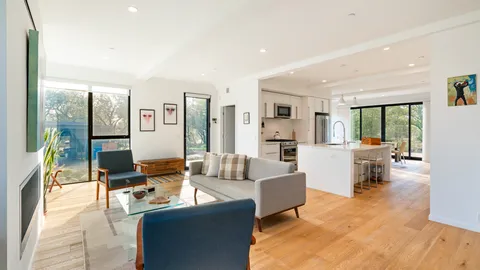 a living room with fireplace furniture and a large window