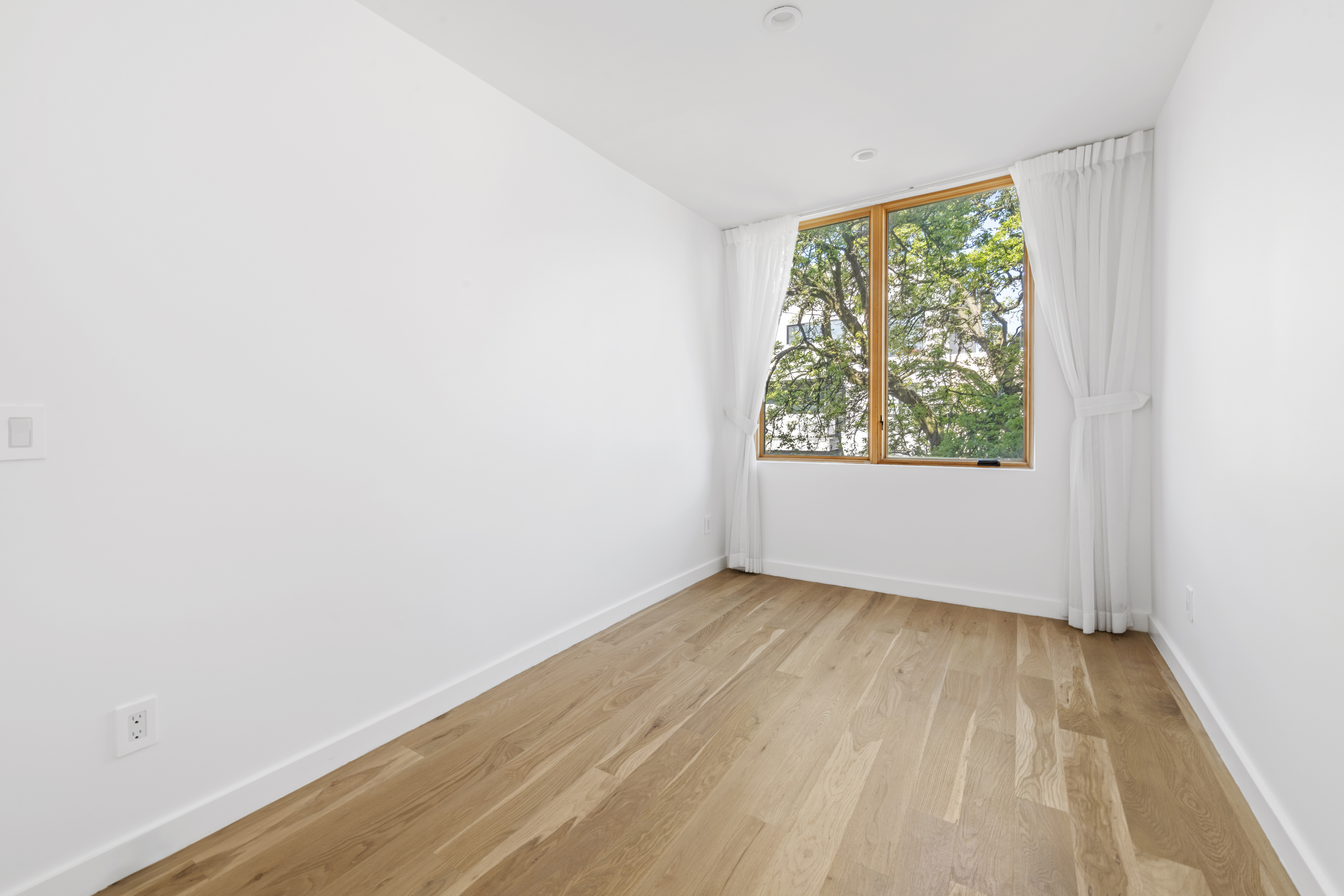 42 Rochester Avenue, Unit 3 Brooklyn, NY 11233 - Photo 13 of 18 an empty room with wooden floor and windows