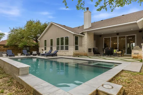 a view of a house with pool and sitting area