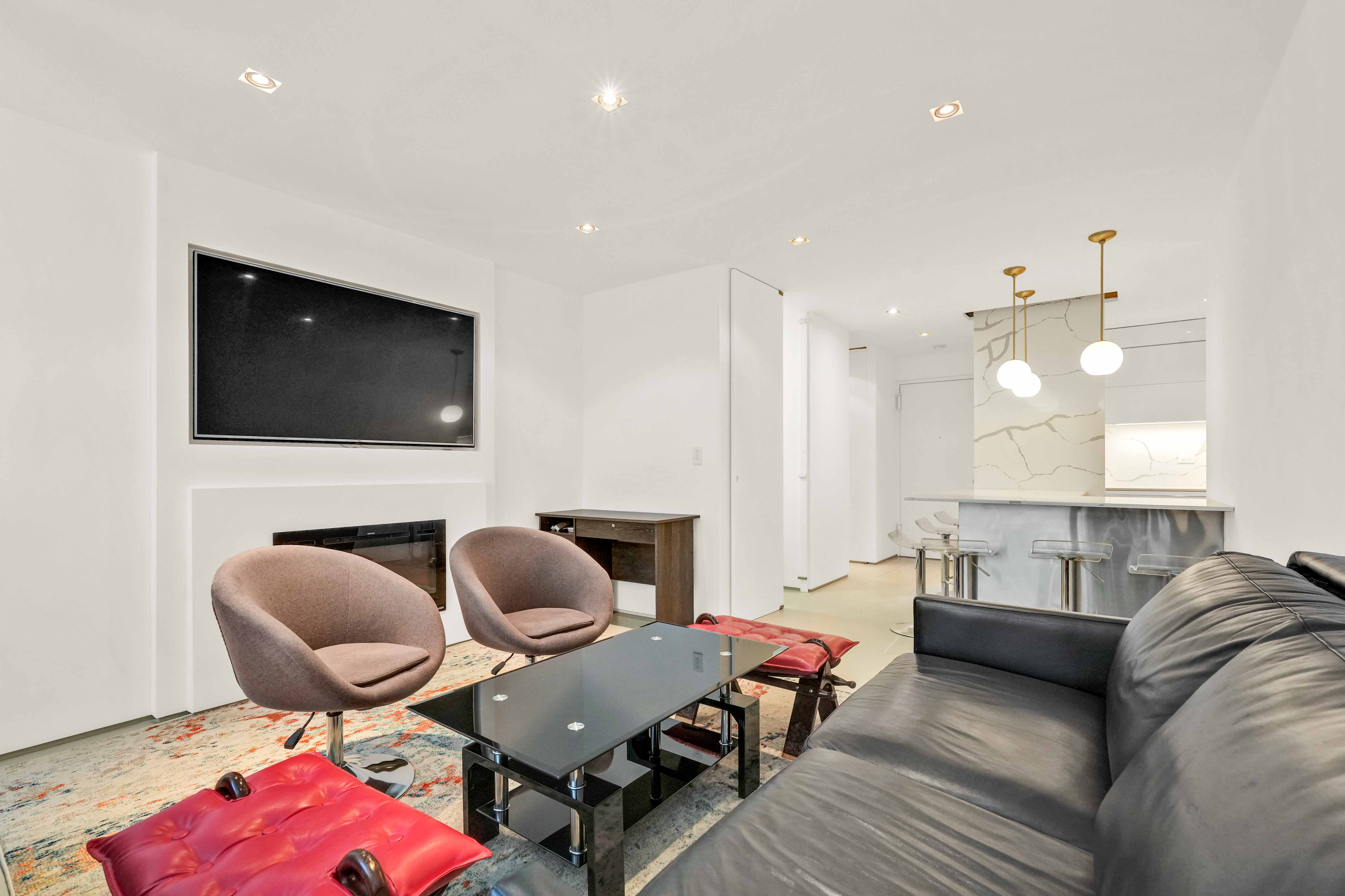 117 East 57th Street, Unit 20F Manhattan, NY 10022 - Photo 1 of 18 a living room with furniture and a flat screen tv