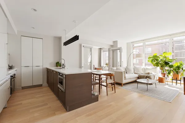 a kitchen with stainless steel appliances granite countertop a stove a sink dishwasher and a refrigerator with wooden floor