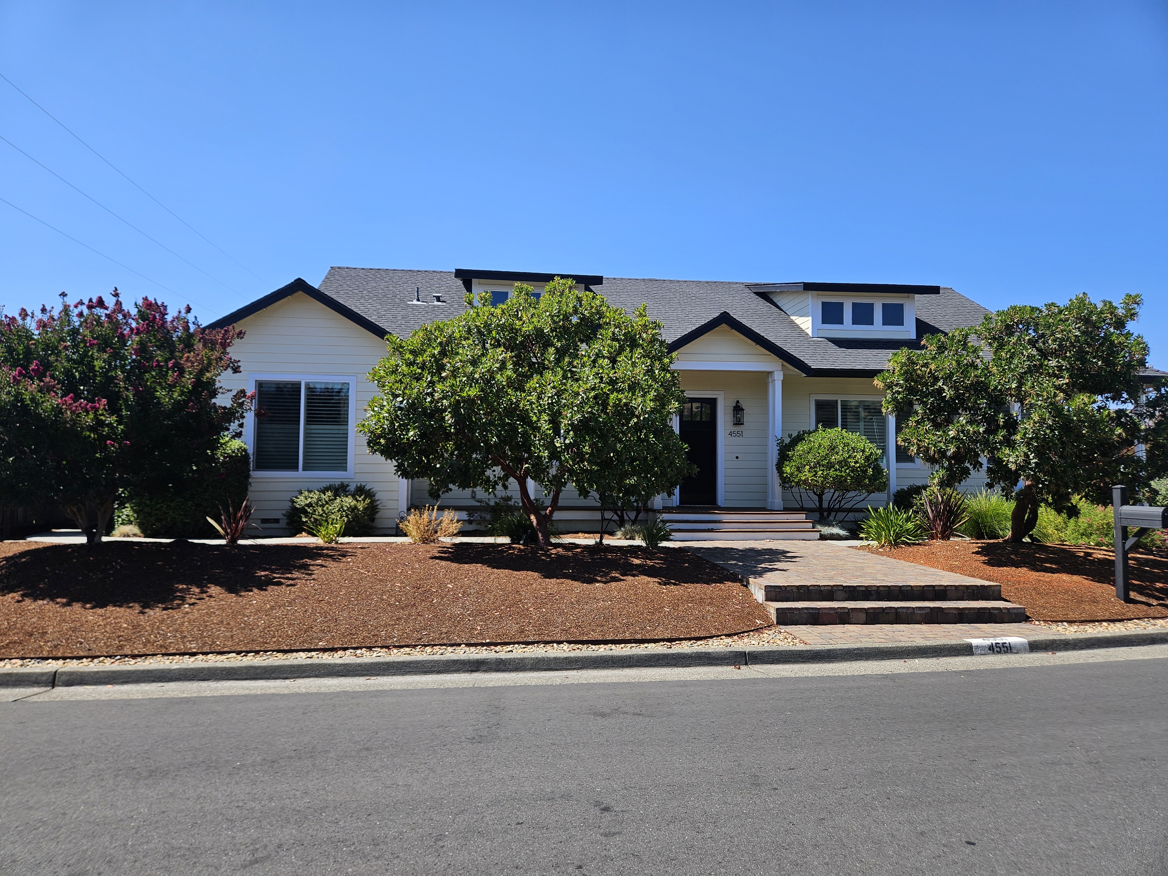 a front view of a house with garage and plants