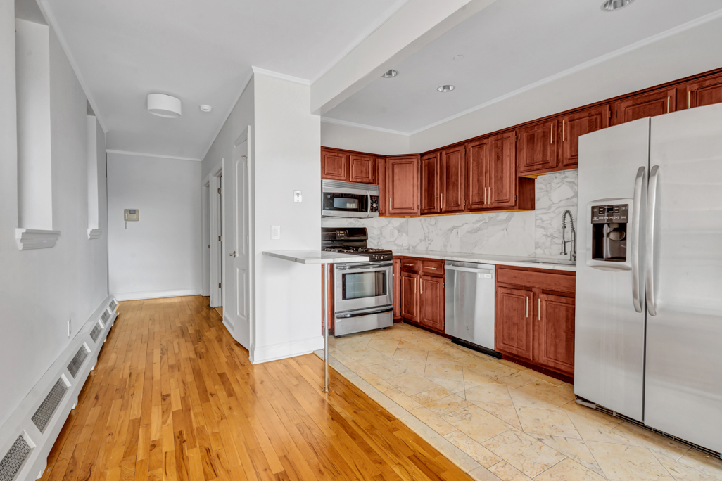 2098 Frederick Douglass Boulevard, Unit 5E Manhattan, NY 10026 - Photo 5 of 8 a kitchen with stainless steel appliances granite countertop a refrigerator and a stove top oven