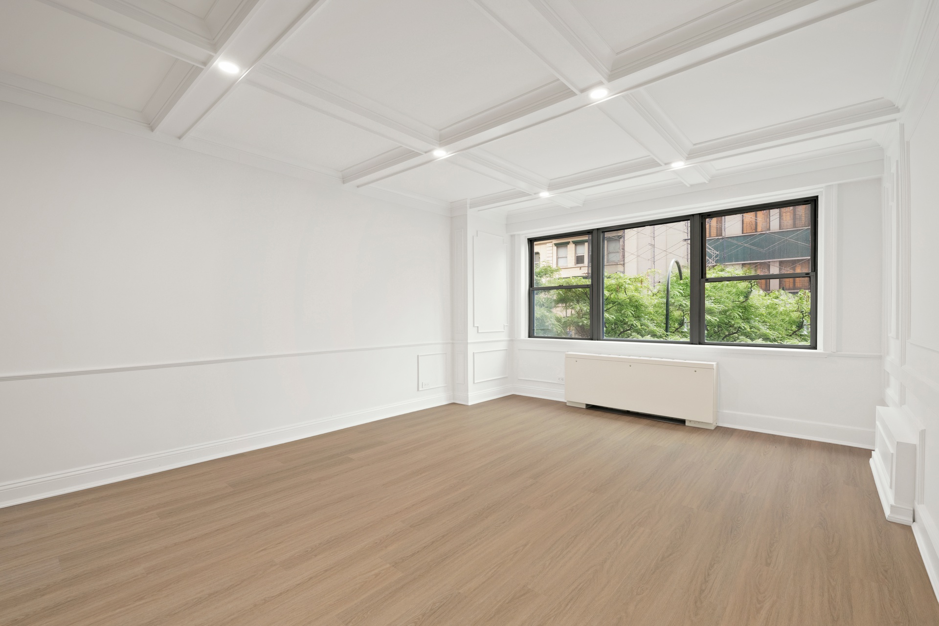 10 West 15th Street, Unit 414 Manhattan, NY 10011 - Photo 3 of 16 an empty room with wooden floor and windows