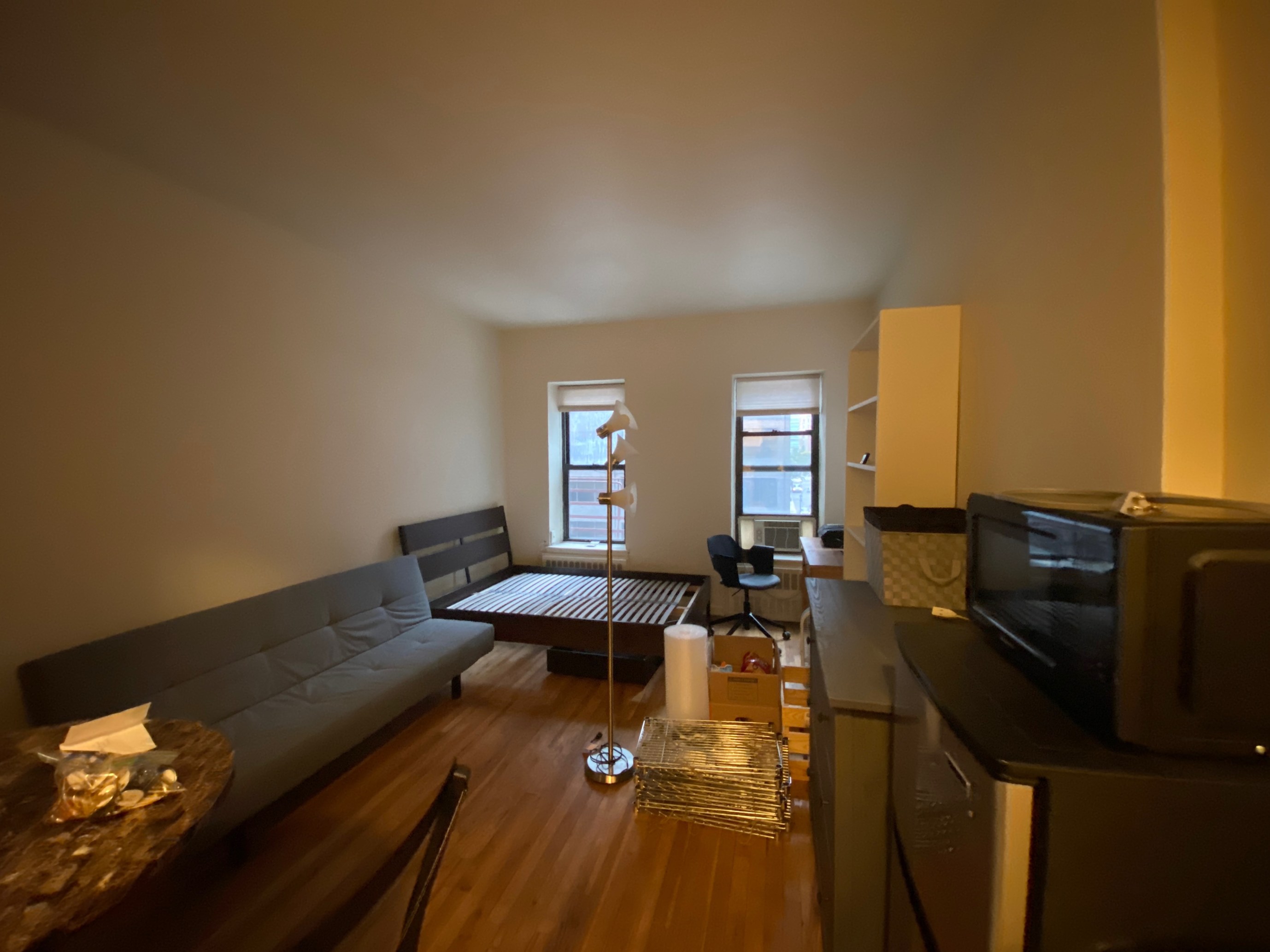 a living room with couches a dining table and chairs with wooden floor