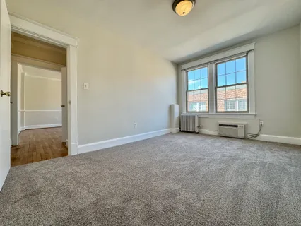 an empty room with windows and closet