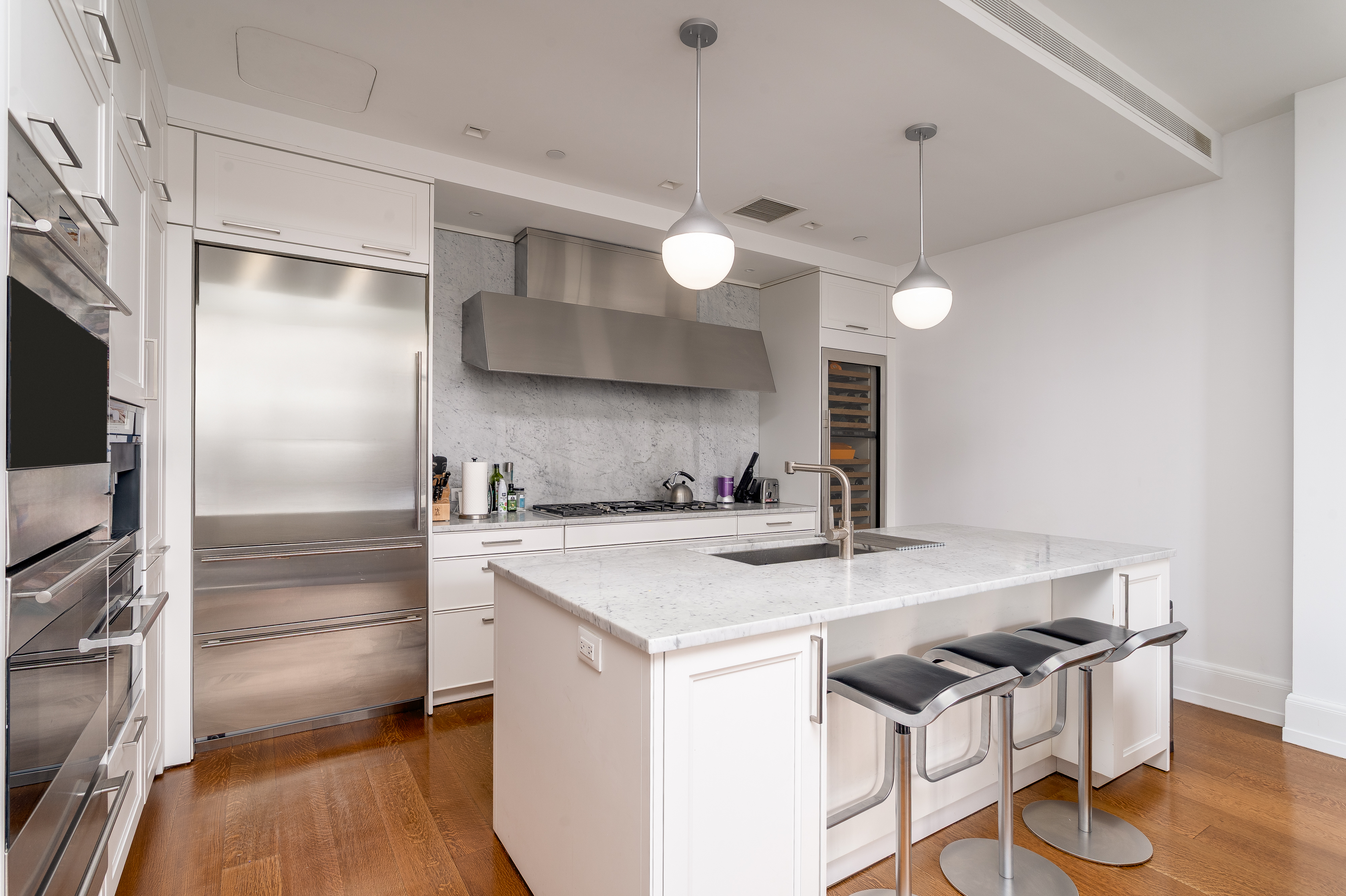10 Madison Square West, Unit 16F Manhattan, NY 10010 - Photo 7 of 15 a kitchen with a stove a refrigerator and a chandelier