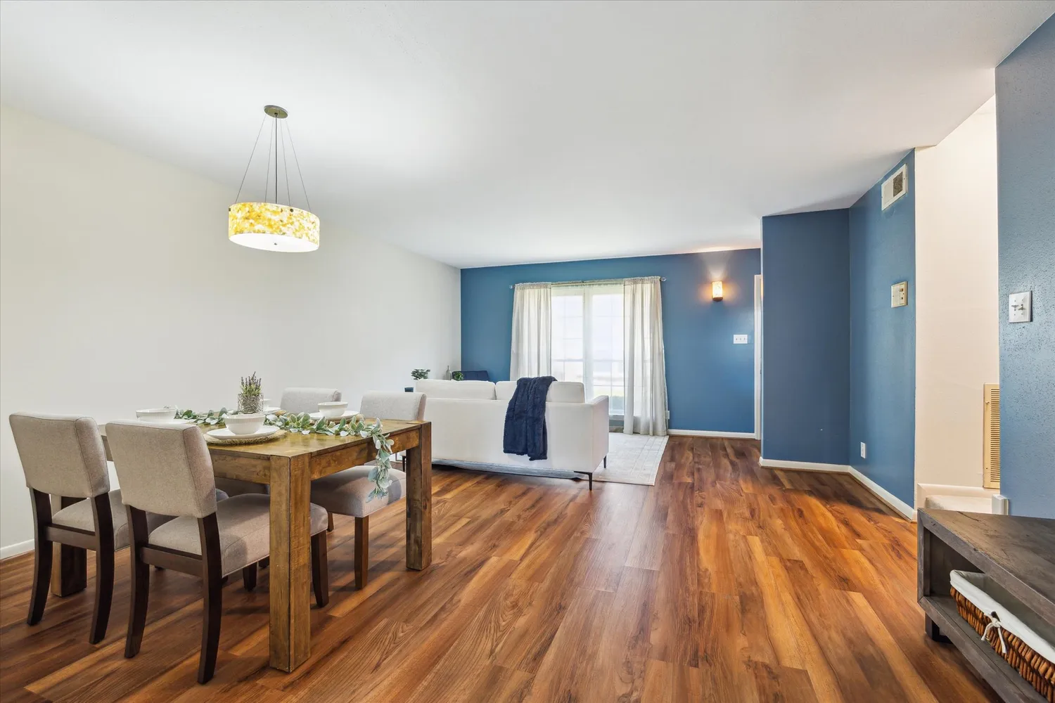 a view of a dining room with furniture wooden floor and chandelier