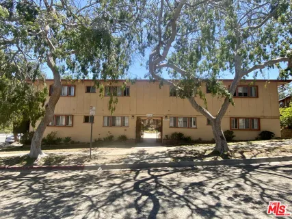 front view of a house with a large tree