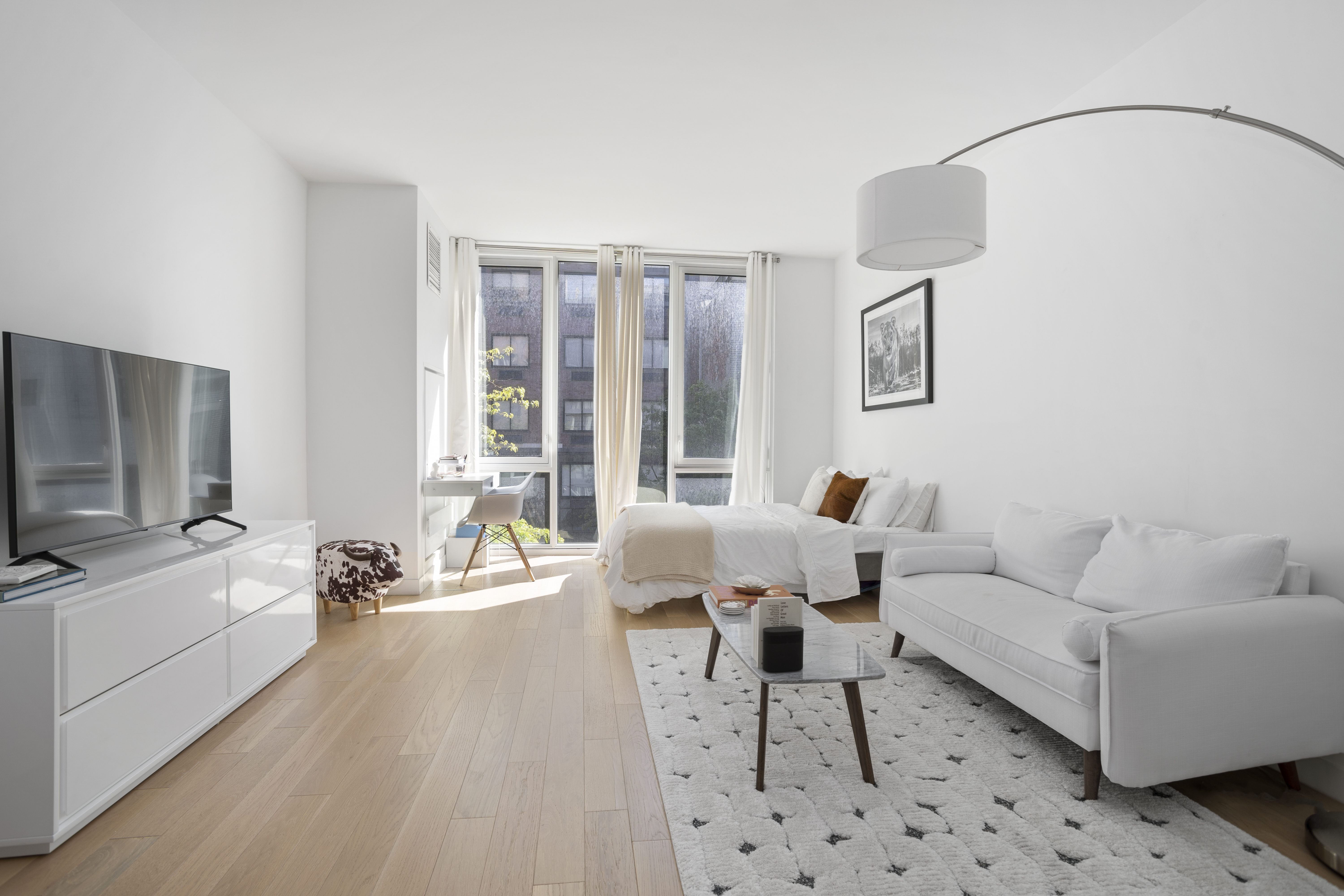 540 West 49th Street, Unit 405S Manhattan, NY 10019 - Photo 2 of 12 a living room with furniture and a flat screen tv