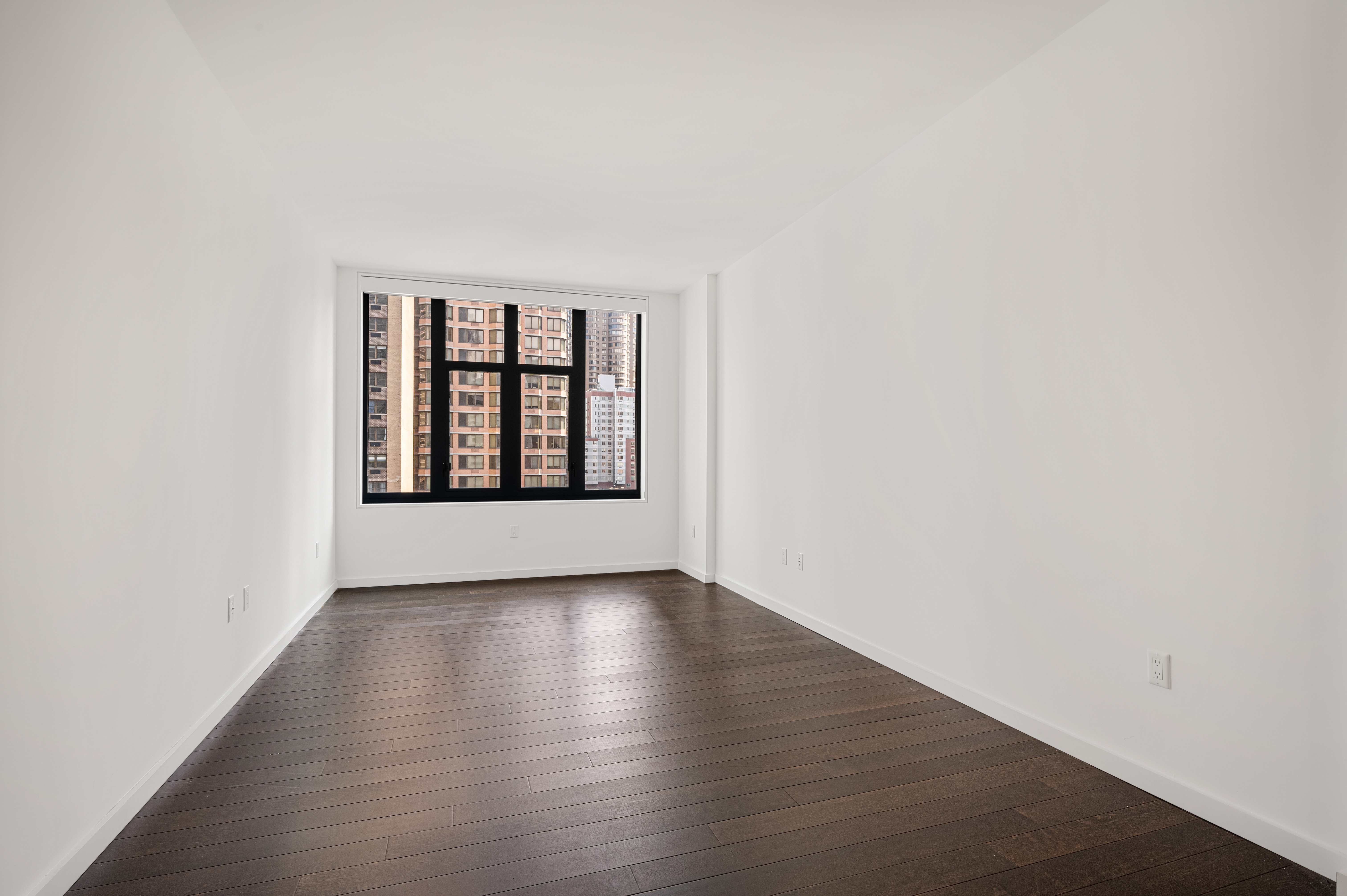 591 3rd Avenue, Unit 9C Manhattan, NY 10016 - Photo 8 of 13 an empty room with wooden floor and windows