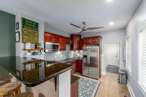 a kitchen with stainless steel appliances granite countertop a sink refrigerator and cabinets