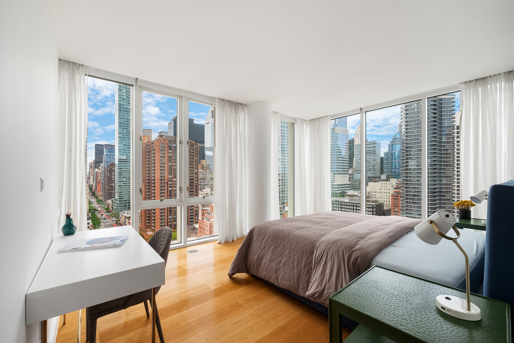 301 East 61st Street, Unit 17A Manhattan, NY 10065 - Photo 6 of 16 a bedroom with a bed and a large window