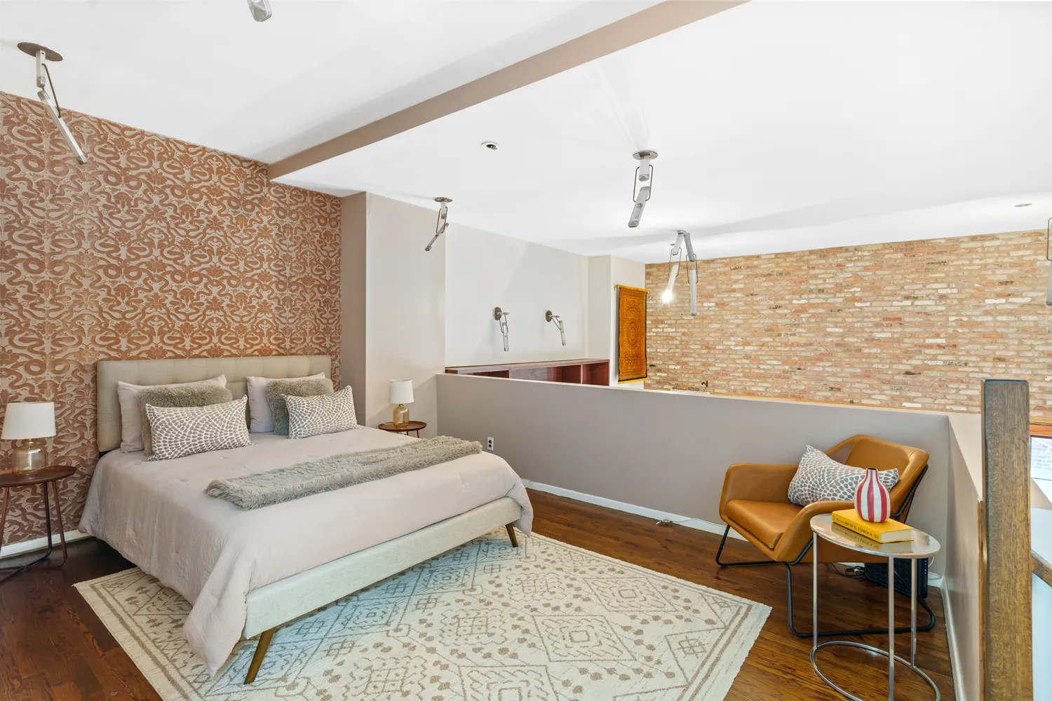 a bedroom with a bed a chair and potted plant