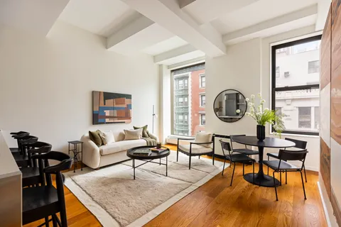 a living room with furniture a rug a lamp and a large window