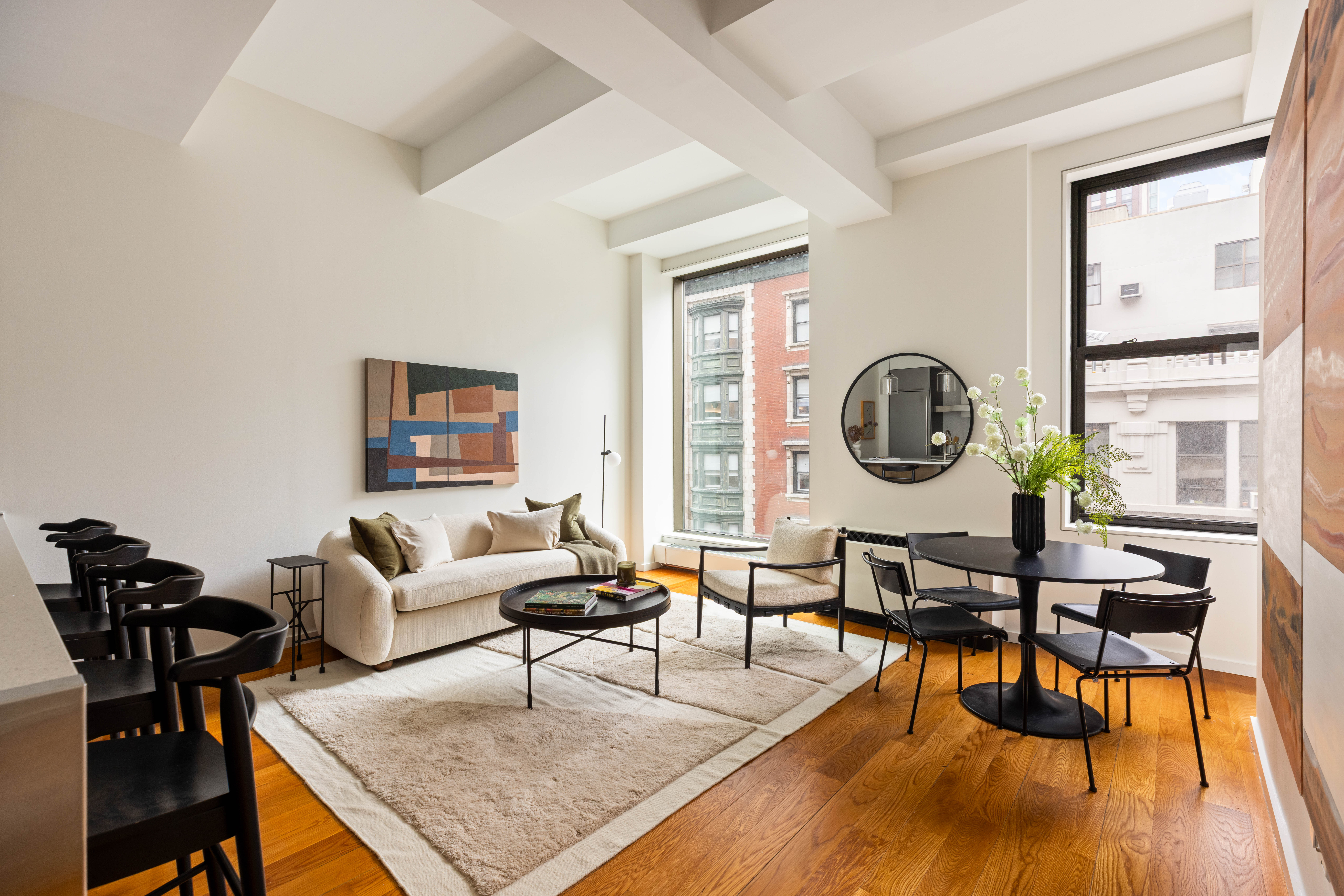 a living room with furniture a rug a lamp and a large window