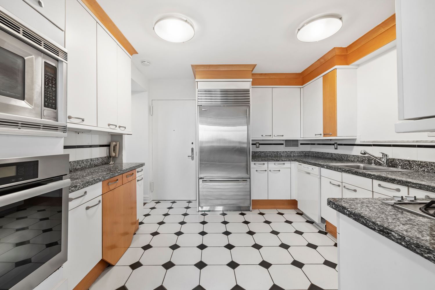 40 East 80th Street, Unit 25A Manhattan, NY 10075 - Photo 5 of 18 a kitchen with granite countertop a sink a stove and refrigerator
