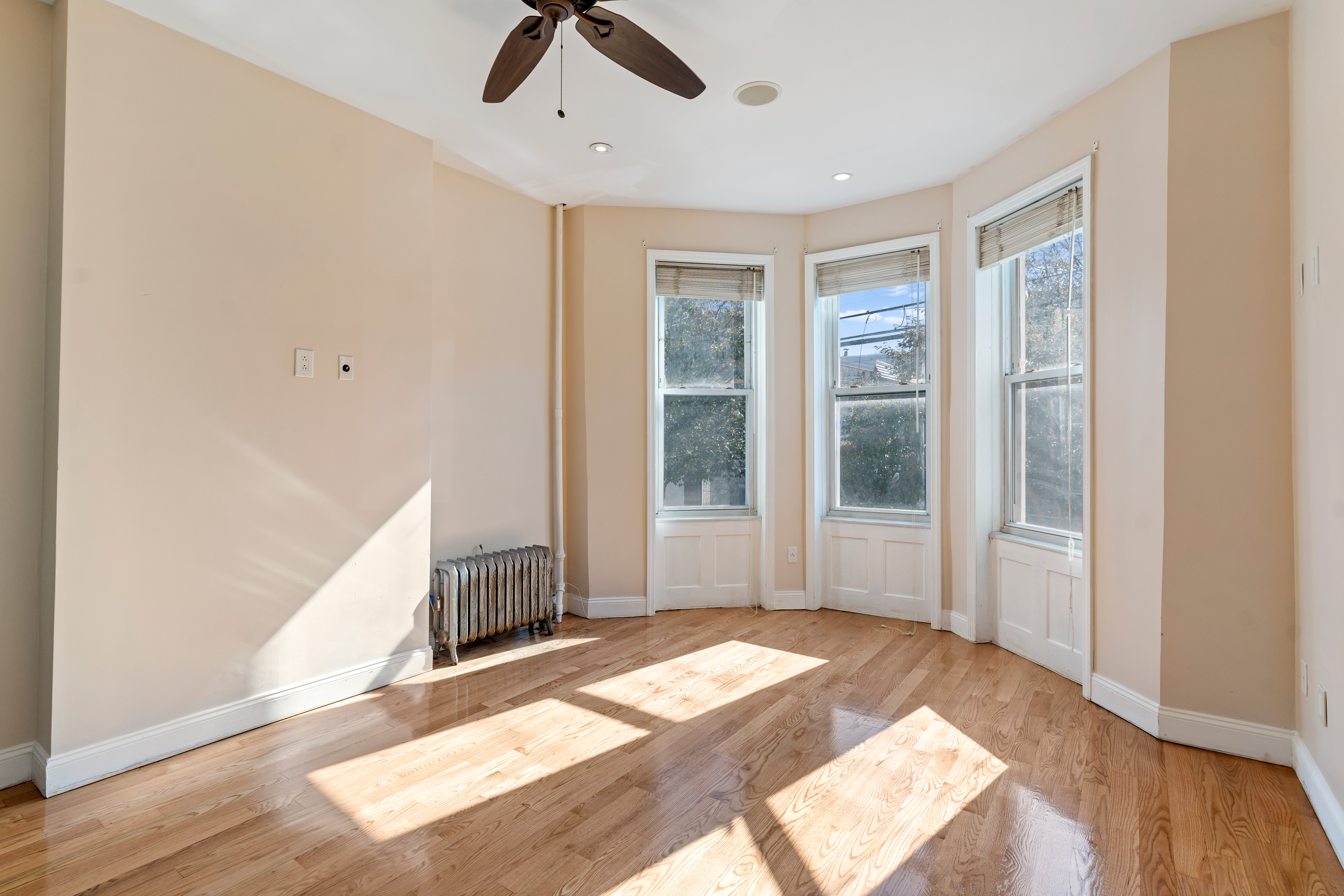 60-13 Menahan Street, Unit 1 Queens, NY 11385 - Photo 11 of 19 a view of an empty room with wooden floor and a window
