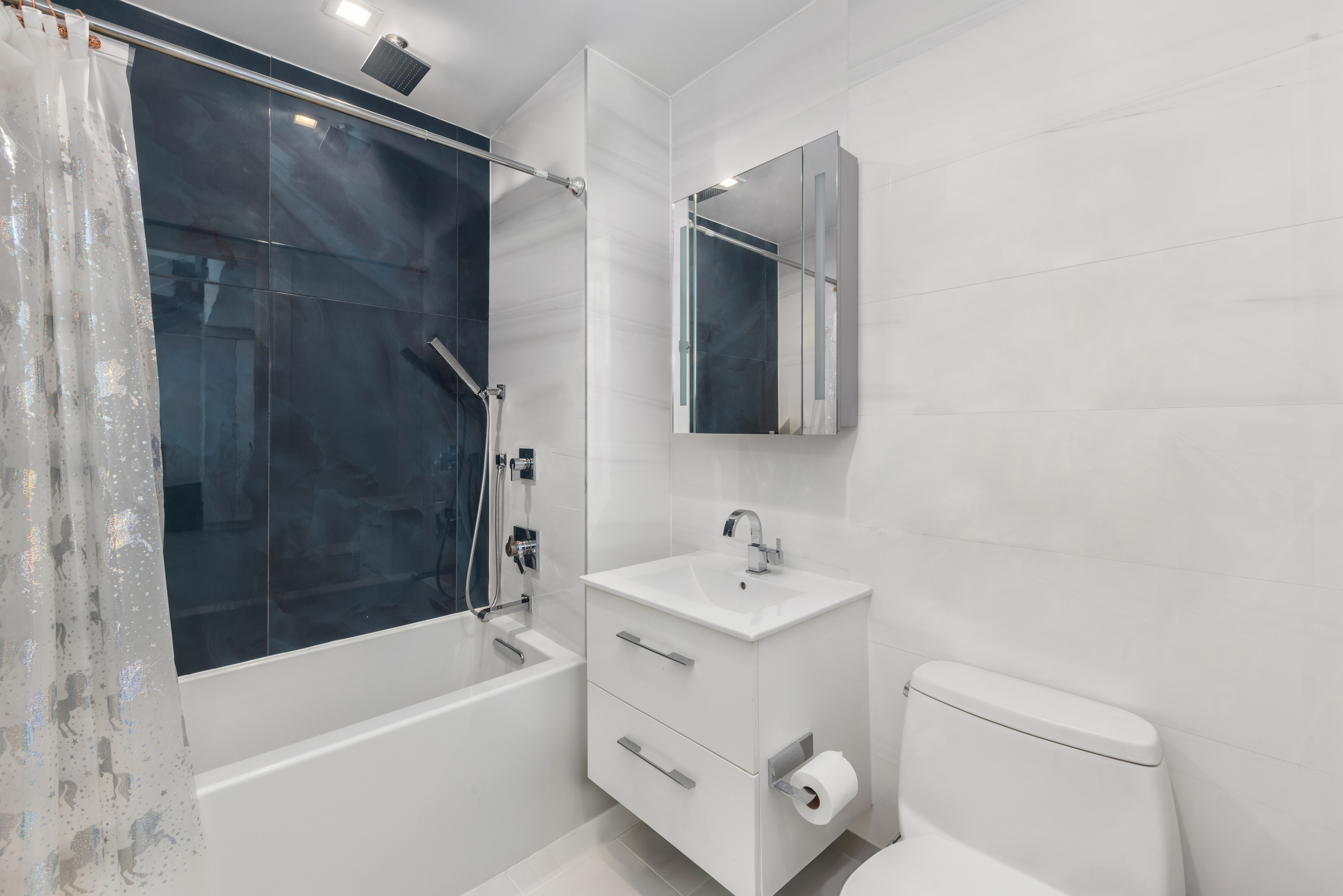 42-44 Crescent Street, Unit PHB Queens, NY 11101 - Photo 9 of 11 a bathroom with a tub a sink and a large mirror