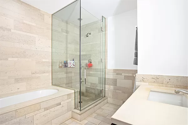 450 East 83rd Street, Unit 3A Manhattan, NY 10028 - Photo 4 of 9 a bathroom with a granite countertop bathtub shower and sink