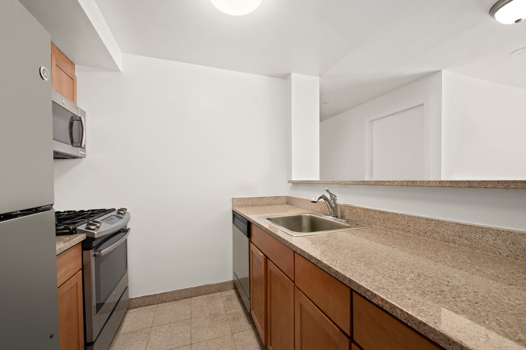 2132 2nd Avenue, Unit 2D Manhattan, NY 10029 - Photo 4 of 6 a kitchen with granite countertop a sink and a stove