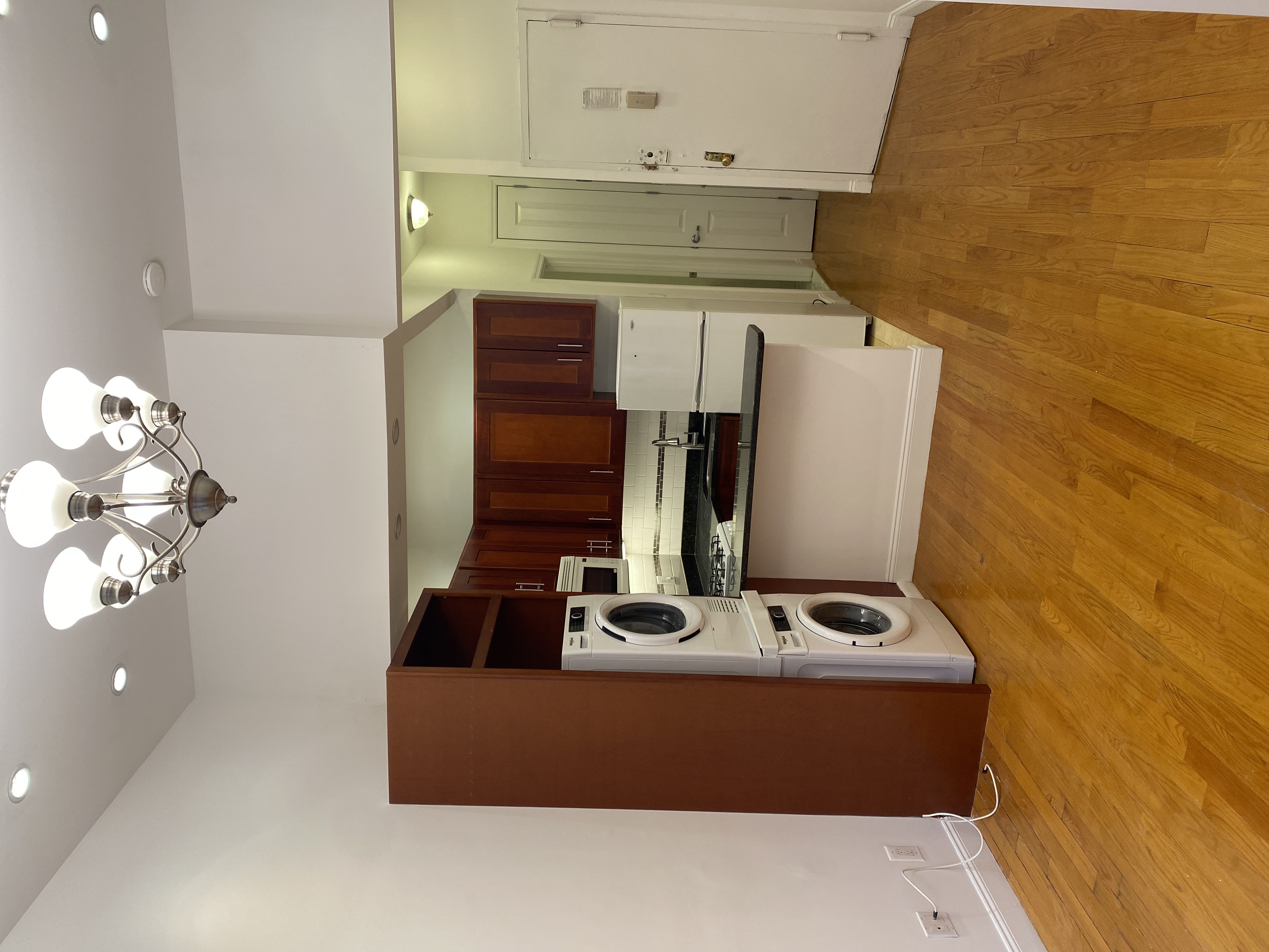 1736 2nd Avenue, Unit DB Manhattan, NY 10128 - Photo 3 of 7 a view of kitchen with stainless steel appliances granite countertop cabinets and chandelier