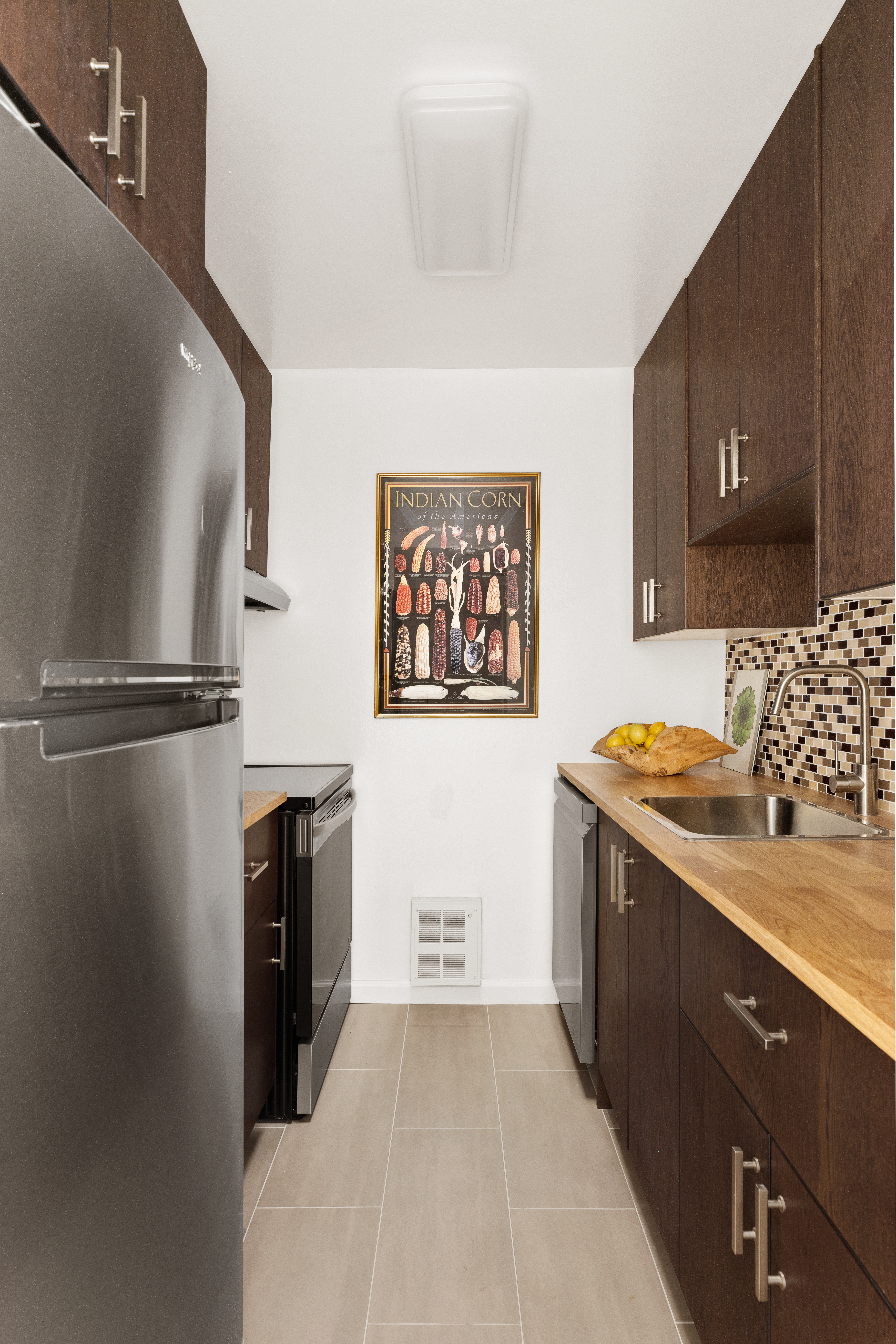 141 Barrow Street, Unit 1B Manhattan, NY 10014 - Photo 6 of 10 a kitchen with stainless steel appliances granite countertop a refrigerator and a stove top oven