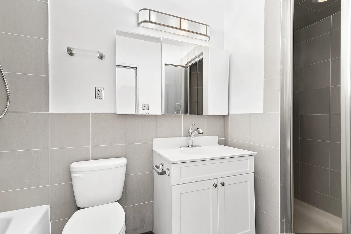 221 East 82nd Street, Unit 6A Manhattan, NY 10028 - Photo 9 of 11 a bathroom with a toilet sink and mirror