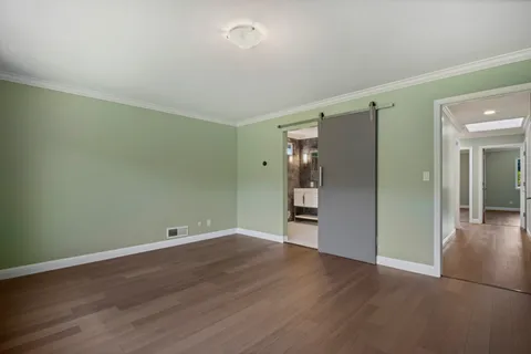 an empty room with wooden floor and window