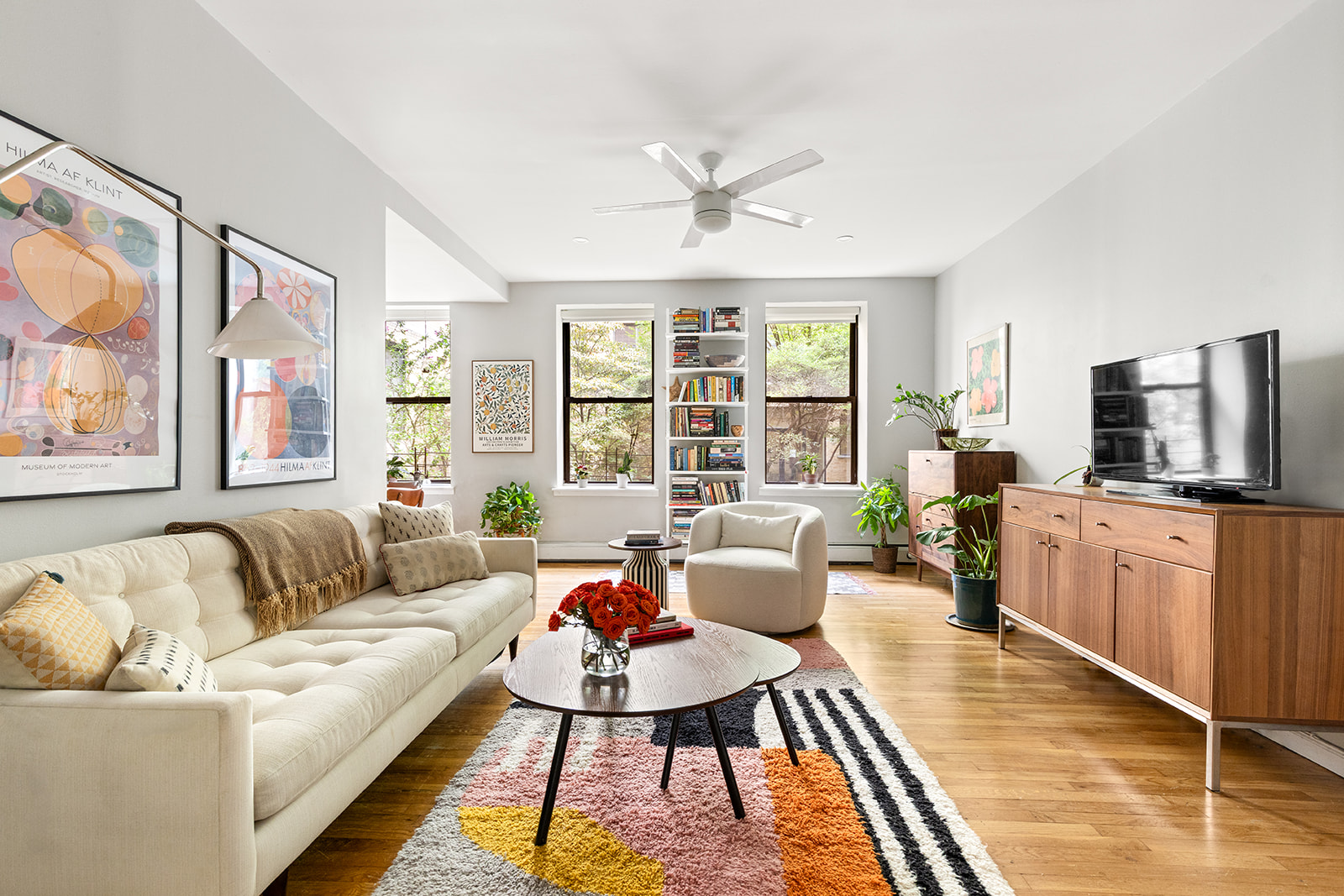 a living room with furniture flat screen tv and window