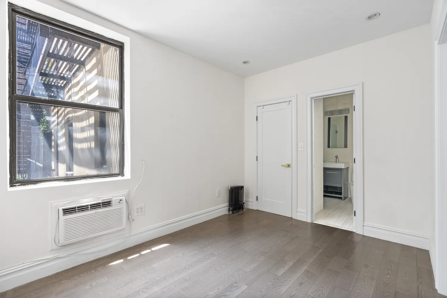 an empty room with windows and closet