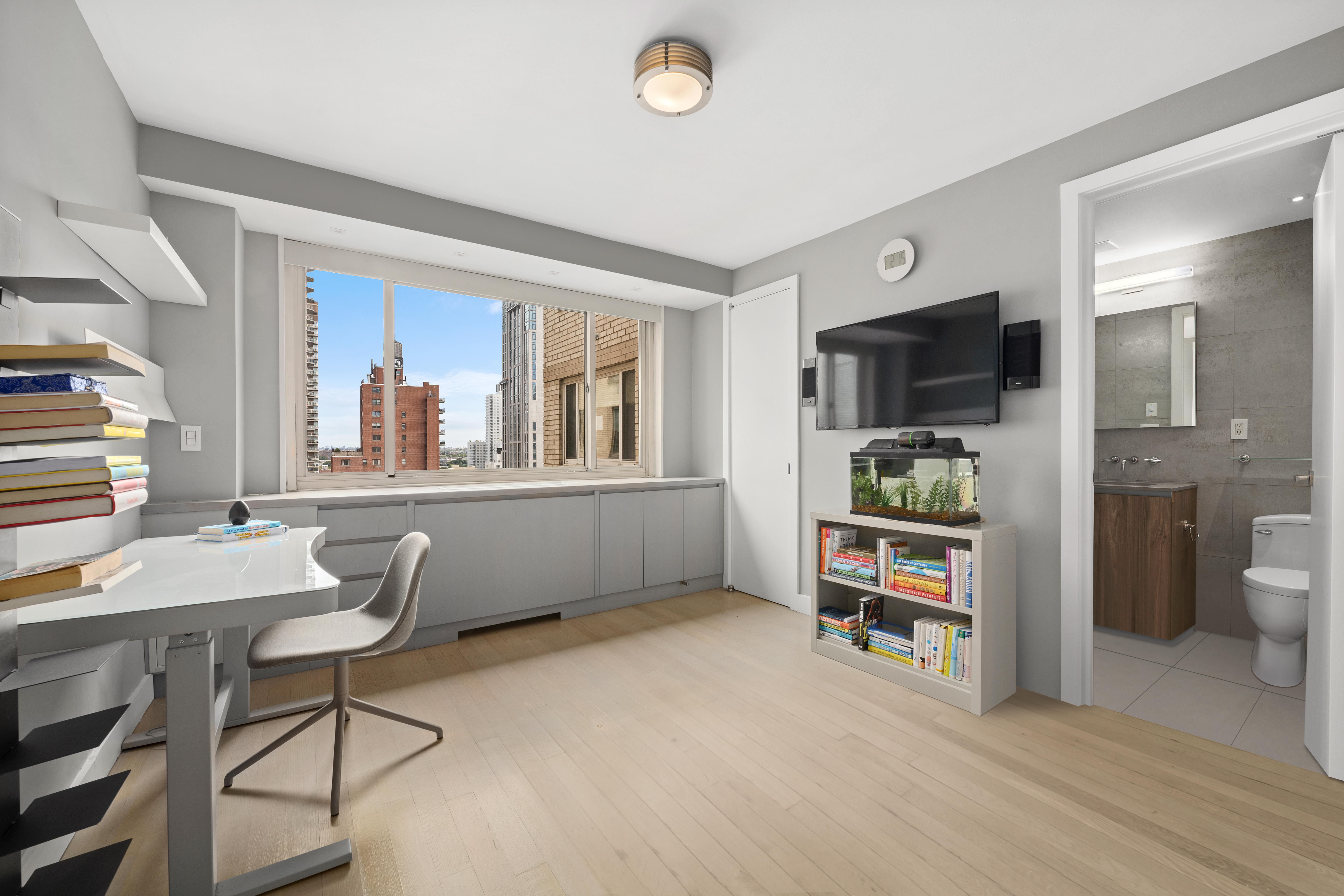 301 East 78th Street, Unit 16EF Manhattan, NY 10075 - Photo 8 of 12 a living room with furniture and a flat screen tv
