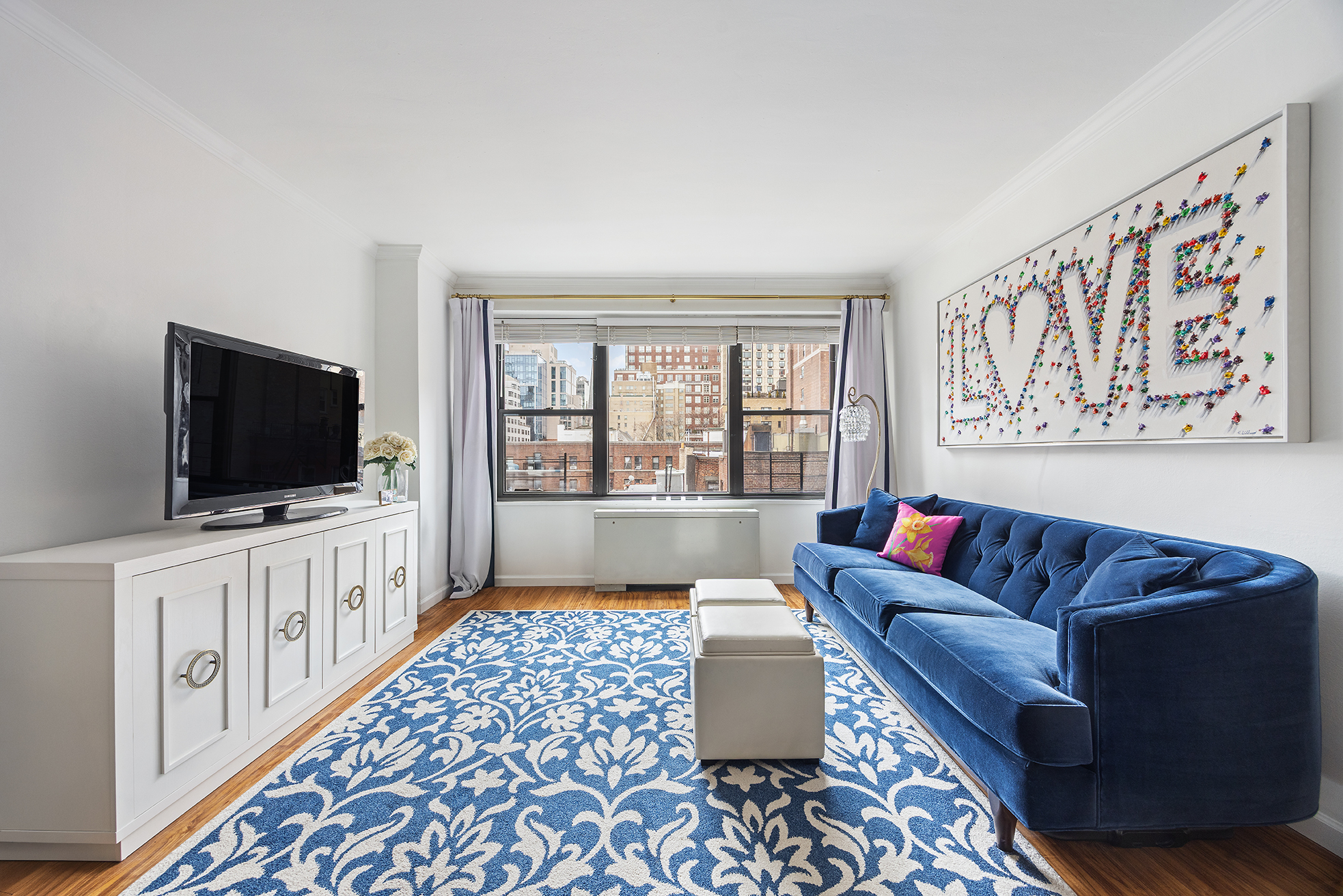 120 East 90th Street, Unit 7B Manhattan, NY 10128 - Photo 1 of 8 a living room with furniture and a flat screen tv