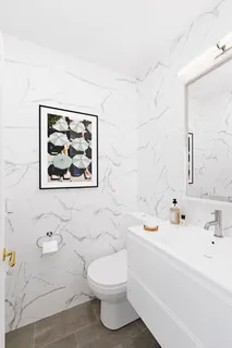 a bathroom with a sink mirror vanity and toilet