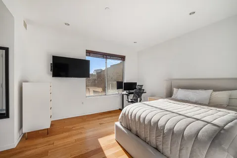 a bedroom with a bed and a flat screen tv