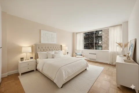 a bedroom with a bed flat screen tv and a large window