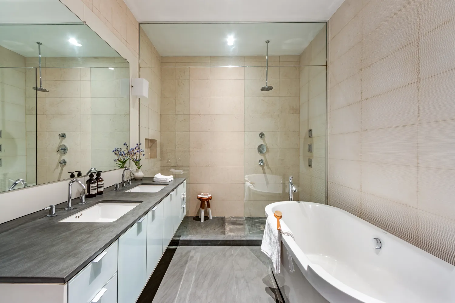 a bathroom with a granite countertop double vanity sink a mirror a bathtub and shower