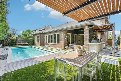 a view of a house with pool and chairs